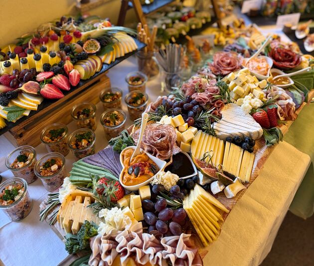 Großzügige Käse- und Wurstplatte mit Obst und kleinen Salaten für Events
